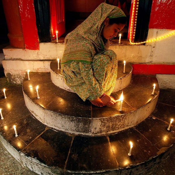 A Kashmiri girl lights candles to celebrate Diwali in Srinagar on Saturday. (PTI Photo)