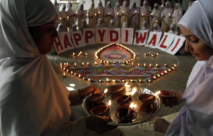 <b>Diwali knows no bounderies:</b> Muslim students light earthen lamps to mark Diwali, the festival of lights, at a school in Ahmadabad. (AP Photo)