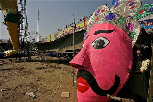 <b>Ravana's D-day:</b> A worker walks past the head of an effigy of Demon king Ravana which will be burnt to celebrate the Dussehra festival, in New Delhi. (AP)