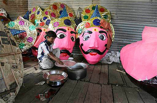 <b>Hard work:</b> A worker checks the food kept for other workers as the heads of 10 headed demon king Ravana lies ahead of Hindu festival Dussehra festival, in New Delhi. (AP)