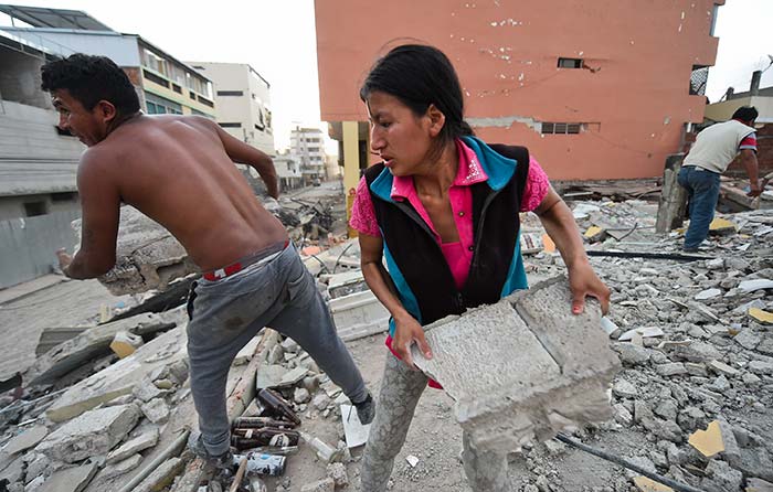 Ecuadorean Veronica Paladines, removes rubble in search for her husband at Tarqui neigbourhood in Manta, Ecuador day after the earthquake. (AFP Photo)