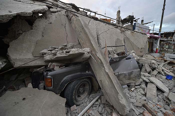 Car buried under the ruins after the devastating eartquake. (AFP Photo)