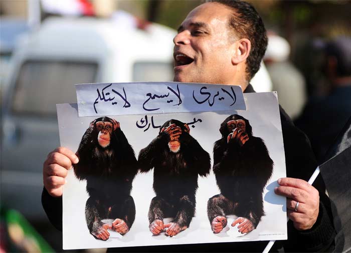 An Egyptian demonstrator holds a picture of the "Three Wise Monkeys" to show that President Hosni Mubarak "doesn't hear, listen or talk. (AFP Photo)