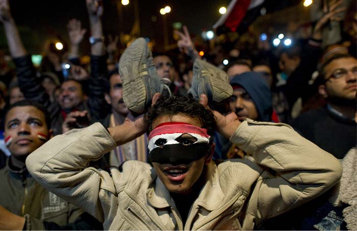 A young man waves his shoes as he reacts to Hosni Mubarak's speech, who failed to announce his immediate resignation. (AFP Photo)