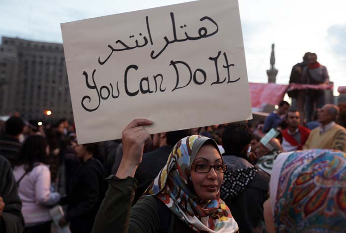 A woman holding a sign that reads in Arabic and English "Hitler committed suicide, you can do it" at the Tahrir Square on Thursday, the 17th day of protests calling for the ouster of President Hosni Mubarak. (AFP Photo)