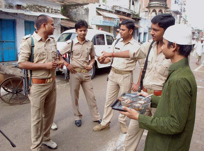 A boy sells vermicelli to policemen in Srinagar on the occasion of Eid.