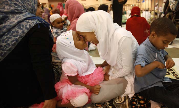 Safia Durri, 3, plays with her mother Hanan Abubeke before the Eid ul Fitr prayer service and celebration at Reliant Center in Houston.