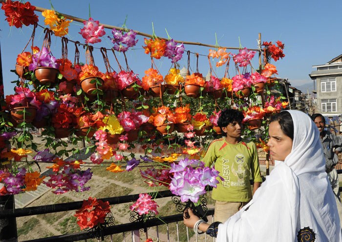 <strong>Flowers for festival:</strong> A shopper buys flowers at an outdoor market, ahead of Eid-ul-Fitr in Srinagar.<br />
<br />
The markets in Srinagar and other major towns of Kashmir valley have been hit by a heavy rush of people out on a shopping binge in preparation for Eid-ul-Fitr. <em>(AFP)</em>