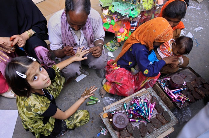 <strong>Adding colours to festivity:</strong> A Kashmiri girl gets her hand decorated with henna ahead of Eid-ul-Fitr in Srinagar.<br />
<br />
Roadside bazaars have sprung up in most parts of the city to woo the shoppers with mutton, poultry, bakery products, sweets, ready-made garments, shoes, toys, fire-crackers and bangles, which is the most sought after item. <em>(AP)</em>