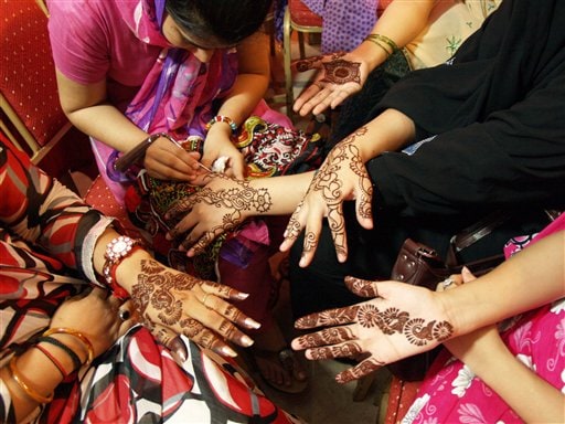 Pakistani girls paint hands with <i>henna</i> to celebrate Eid. Women buy new clothes and accessories on this occasion which is also a very integral part of the festivities.(AP Photo)