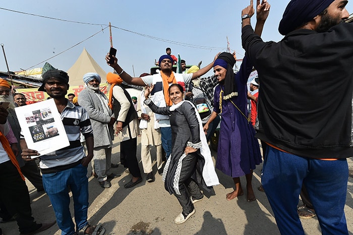 Farmers dance to celebrate after PM Modi announced the repealing of the three farm laws, at Singhu Border.
