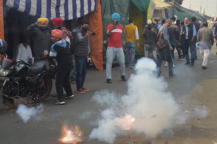 Farmers burst crackers as they celebrate the repealing of the three farm laws, at Ghazipur border.