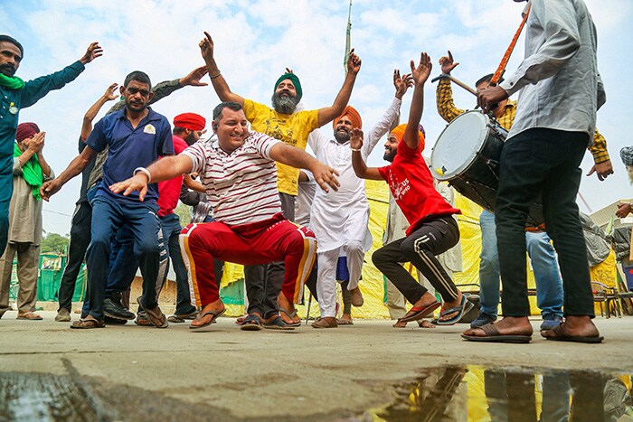 Farmers dance to celebrate after PM Modi announced the repealing of the three farm laws, at Tikri border.