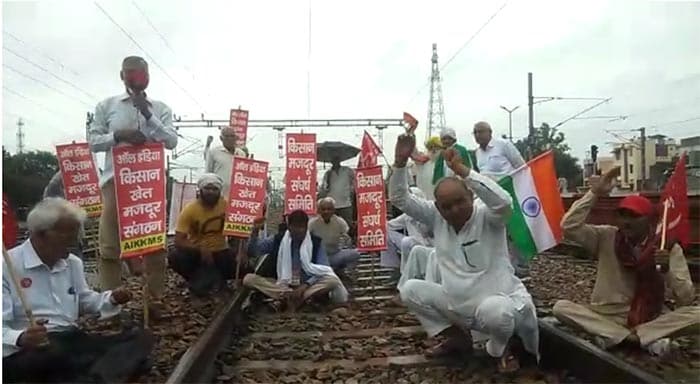 Farmers gathered with signs and chanted slogans while agitating on train tracks in Sonipat, Haryana.