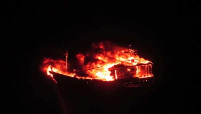 The boat allegedly slowed down and several loud explosions followed, then a massive fire erupted on the boat. Four men were seen on the boat before it sank.