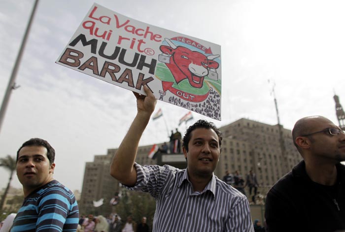 One of the anti-government protesters holds a poster slamming Egyptian President Hosni Mubarak. The military guarded thousands of protesters pouring into Cairo's main square on Friday in an attempt to drive out Mubarak after 11 days of pro-democracy demonstrations. (AP Photo)