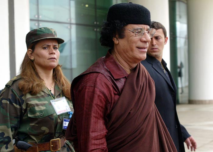 Colonel Gaddafi is followed by his bodyguard as he leaves the closing session of the 17th Arab Summit in Algiers 23 March 2005. (AFP Photo)