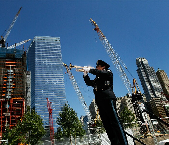 Hundreds of family members placed roses in a reflecting pool at Ground Zero in front of a memorial, leaving scrawled remembrances on paper around it. Visible behind the podium of mourners were the beginnings of two skyscrapers rising at the site along with a transit hub. (AFP)