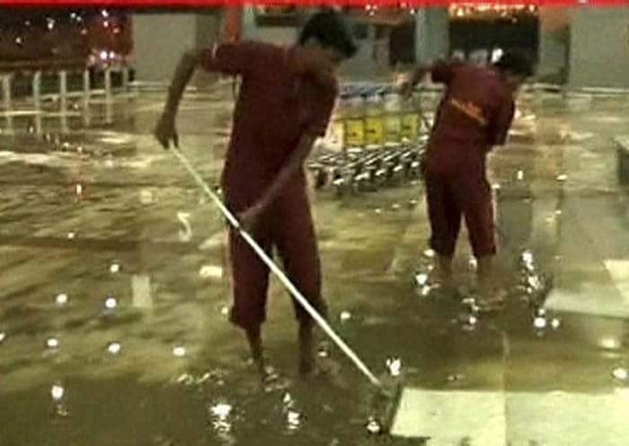 Sweepers clear water logging after heavy rains, which affected passenger movement at IGI airport T3.