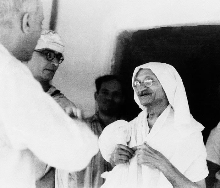 Mahatma Gandhi chatting with Jawaharlal Nehru in the doorway of the house where they conferred in Wardha, Bombay, September 9, 1942. At far left is Gandhi's secretary, Mahadev Desai.<br><br> (Photo: AP)