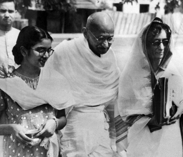 The unstoppable Gandhi, who always advocated a policy of non-violent non-cooperation to achieve independence for India, is seen here walking with Manu Gandhi (L), his grand-daughter. <br><br>(Photo: AFP)