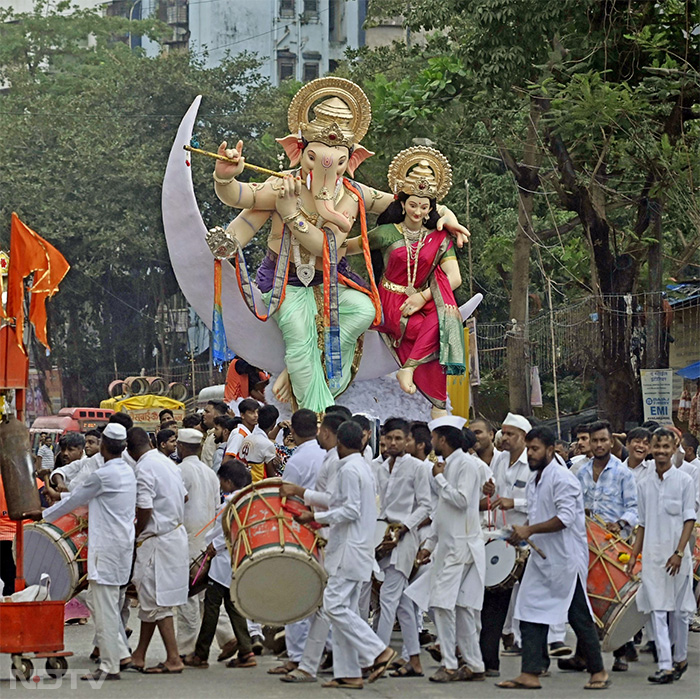 मुंबई में रविवार को 'गणेश चतुर्थी' से पहले जुलूस के दौरान ढोल-नगाड़ों के साथ भक्त गणेश की मूर्ति ले जाते हुए. फोटो: एएनआई