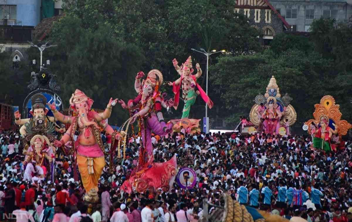 भक्त गणेश की बड़ी-बड़ी मूर्तियों को बैंड-बाजे, ढोल-नगाड़ों के साथ नाचते गाते हुए विदाई दे रहे हैं.