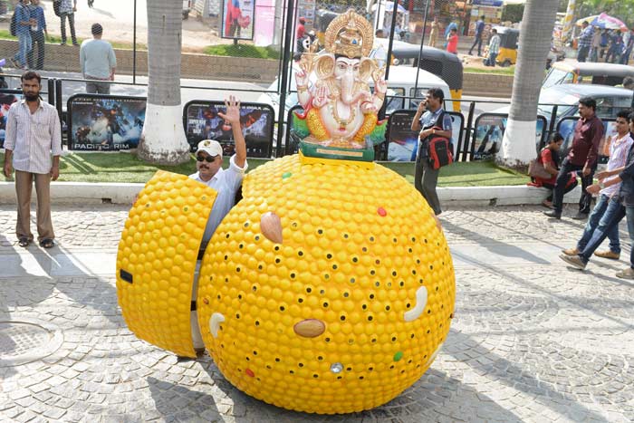 Designer Sudhakar Yadav waves from a self-designed vehicle, styled with an idol of lord Ganesha on top of a drivable 'laddu' - a traditional sweet presented to the Hindu god as offerings - in Hyderabad.