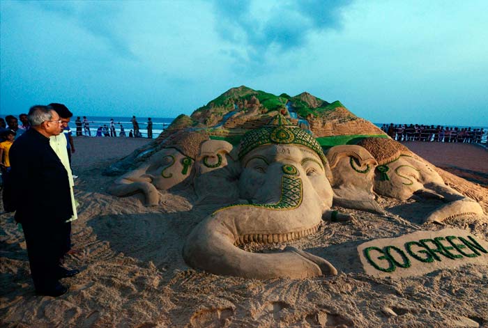 President Pranab Mukherjee taking a look at a sand art on Lord Ganesh with a message Go Green, created by artist Sudarsan Pattnaik in Puri.