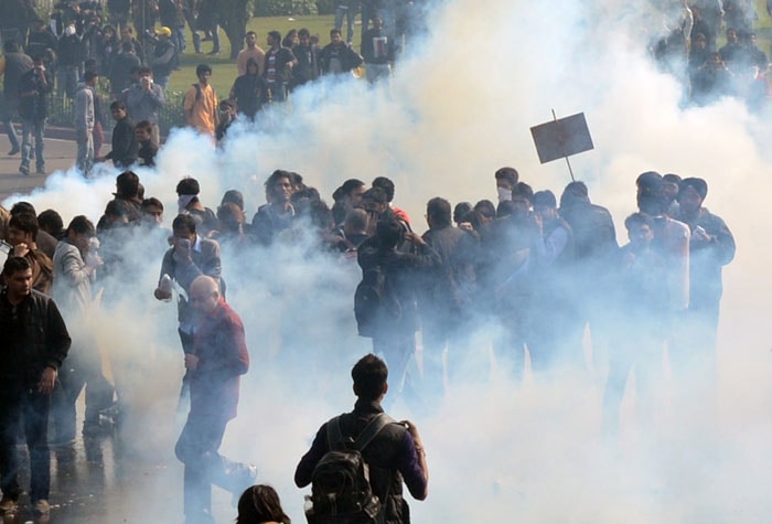 Through the smoke, protestors with placards march on. <br><br>

Picture dated December 22.