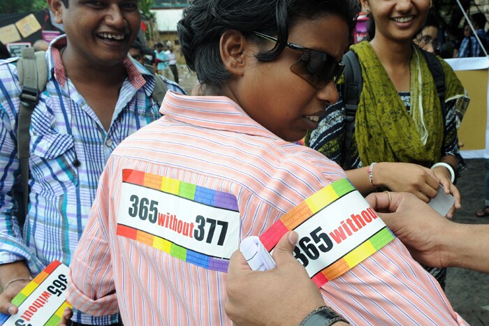 A member of the parade receives stickers from a fellow supporter during a celebration in Mumbai.<br><br>For India's gay community, the joy that greeted last year's court ruling legalising gay sex is marred by the fact that, although the law now accepts them, society still does not. (AFP Photo)