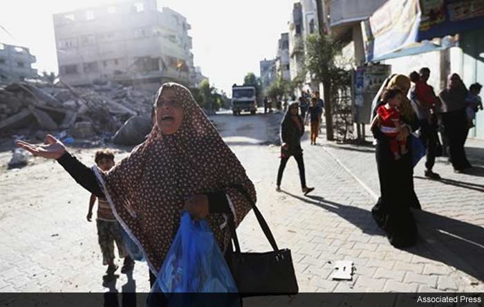 Palestinians flee their homes in the Shajaiyeh neighborhood of Gaza City, after Israel had airdropped leaflets warning people to leave the area, Wednesday, July 16, 2014.