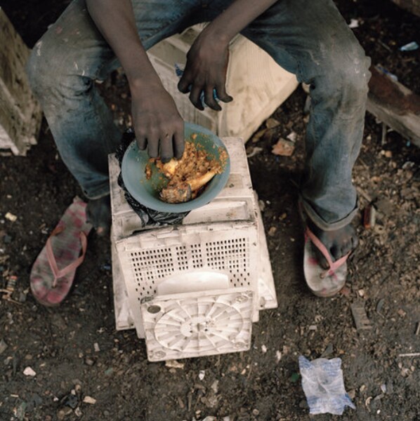 A scavenger stops work for a meal. (Photo credit: Pieter Hugo for The New York Times)