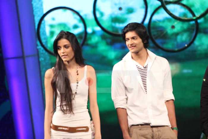 Ali Fazal and Giselli Monteiro stand together.