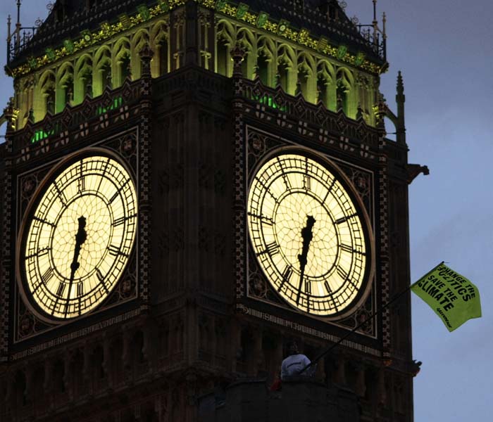 A flag flaps in front of Big Ben after Greenpeace demonstrators scaled the roof of the Houses of Parliament to protest against perceived government inaction on climate change, on October 11, 2009 in London. At least 40 activists occupied the roof of the famous Palace of Westminster in central London, unfurling several yellow banners reading: &quot;Change the politics, save the climate&quot;. (AFP Photo)