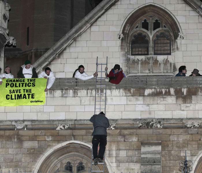 A Greenpeace demonstrator climbs down the roof of the Houses of Parliament after taking part in a protest against perceived government inaction on climate change, on October 11, 2009 in London. The activists are vowing to stay on the roof overnight so they can welcome politicians back to Westminster the next morning.&nbsp;(AFP Photo)