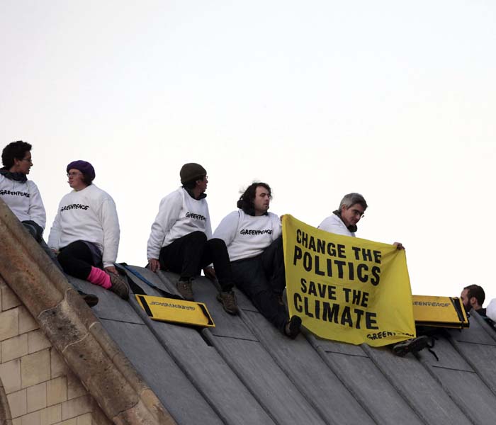 Greenpeace demonstrators sit on the roof of the Houses of Parliament to protest against perceived government inaction on climate change, on October 11, 2009 in London. The protestors are calling for a new style of politics in Britain, one capable of rising to meet the challenge of climate change. (AFP Photo)