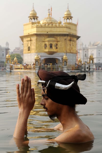 A Sikh devotee pays his respects while taking a ritual bath at the Golden Temple.(AFP Photo)