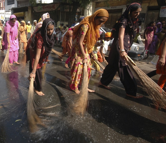 Devotees clean the road during a religious procession to mark the birth anniversary of Guru Nanak, who founded the Sikh religion. (AP Photo)