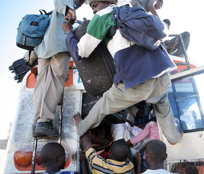 Haitians scramble to board a bus headed out of the city at the main depot in Port-au-Prince, Haiti. (NYT photo)