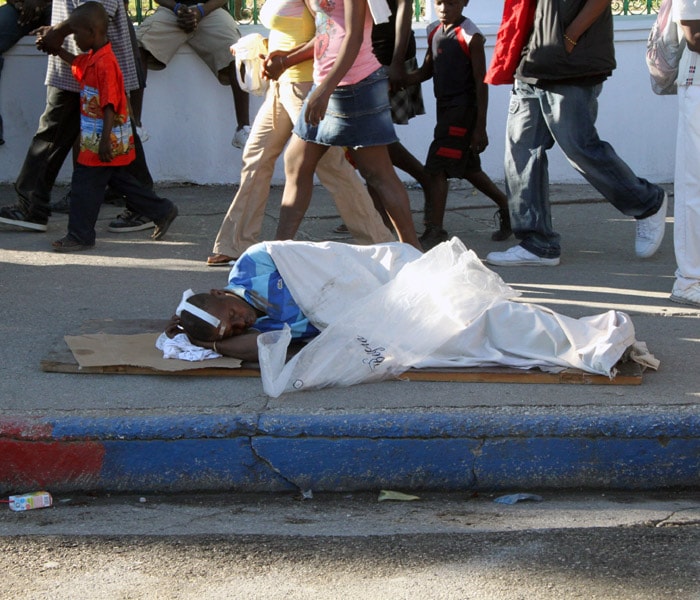 A major quake of 7.3-magnitude rocked the Caribbean nation of Haiti on 12th January 2010 and damaged presidential palace besides other government buildings in the country's capital Port-au-Prince, an incident termed as "catastrophe of major proportions". This is the largest earthquake to hit the country, since 1984.<br><br>
An injured man lies on a sidewalk in Port-au-Prince, Haiti. Huge swaths of Port-au-Prince lay in ruins, and thousands of people were feared dead in the rubble of government buildings, foreign aid headquarters and shantytowns that collapsed in a powerful earthquake.(NYT photo)