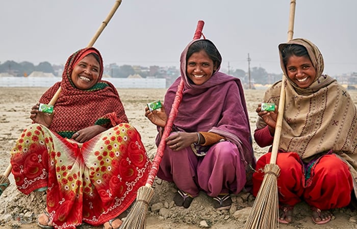 Women proudly hold up their Dettol soaps, inspiring others to prioritise hygiene at Maha Kumbh 2025.