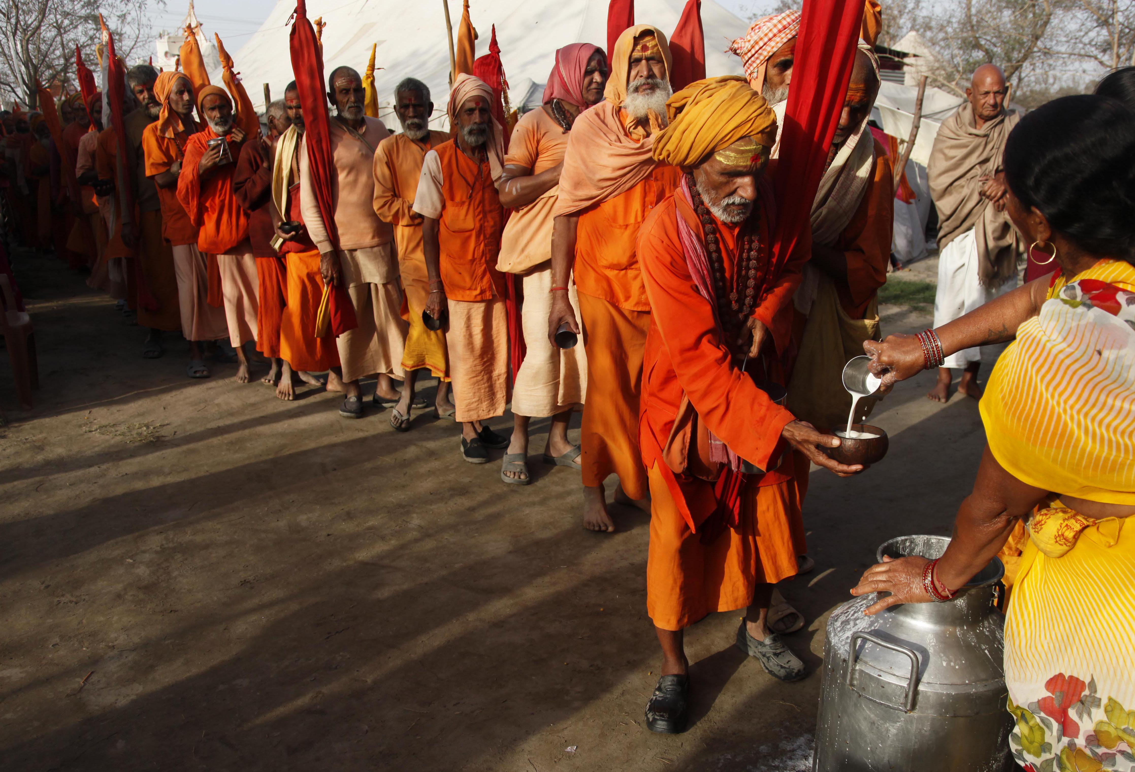 A group of Sadhus stand in a queue to receive prasad being distributed by a woman during the Kumbh Mela in Haridwar. (AP photo)