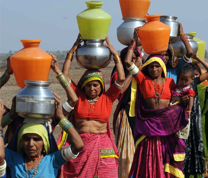 <b>The strive for survival:</b>Women carry water for their families as options for collecting fresh water become few and far in between. (AFP image)