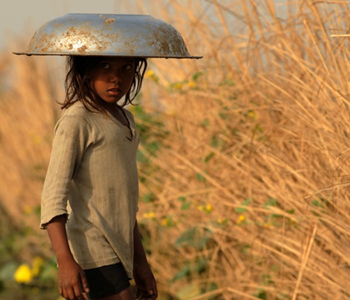 <b>No water, little shadow and a lot of heat:</b>
A child covers herself with a container that she is supposed to carry water with. (AFP image)