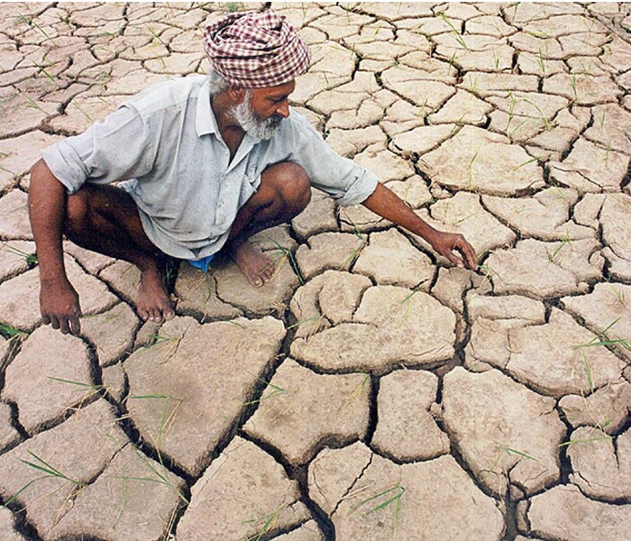 <b>The ugly jigsaw:</b>A farmer touches the bits and pieces of green that remain between the cracks of the parched surface of his land.<br> Lack of irrigation facilities, rising temperatures and low ground water levels have all contributed to become one of the most troubled summers for the people. (AFP image)