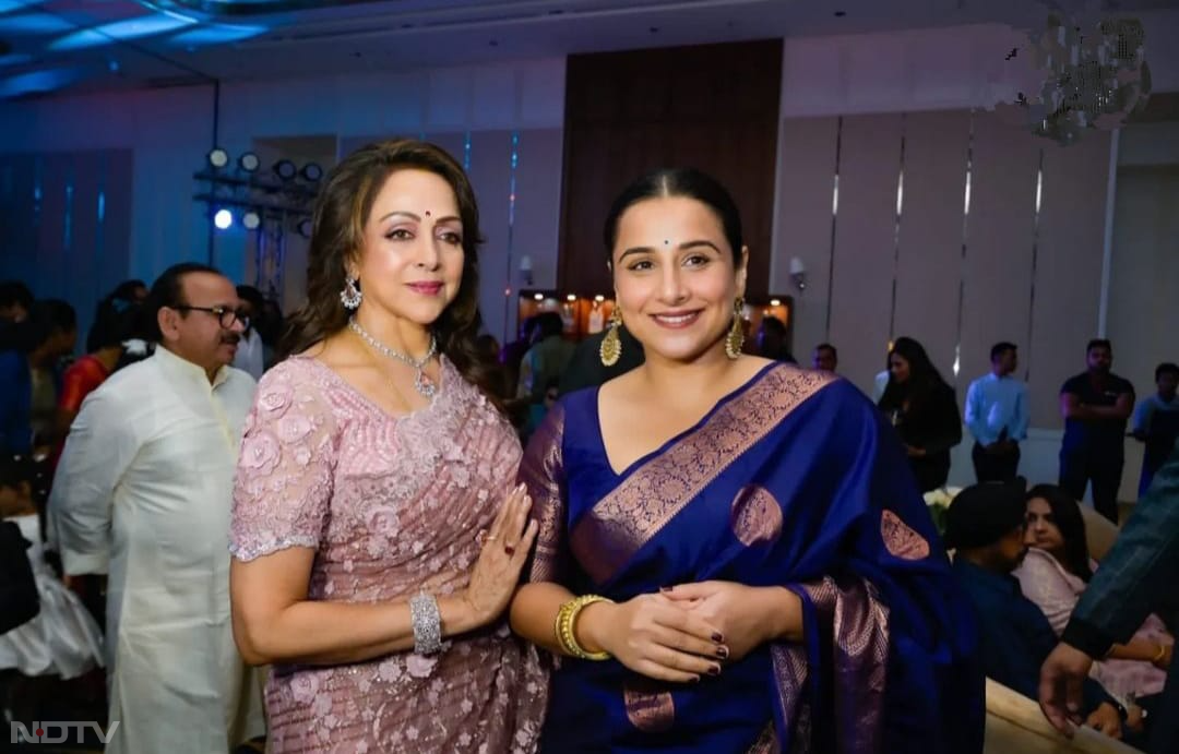 पैपराजी को पोज देते हेमा मालिनी और विद्या बालन. विद्या बालन ब्लू कलर की साड़ी में बेहद खूबसूरत लग रही थी. (फोटो क्रेडिट-इंस्टाग्राम-@dreamgirlhemamalini)