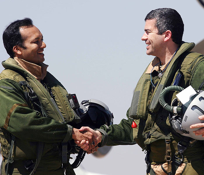 Politician Naveen Jindal shakes hands with an unidentified pilot after flying in the Dassault Rafael aircraft at the Aero India 2011 in Bangalore. (Photo courtesy: AFP)