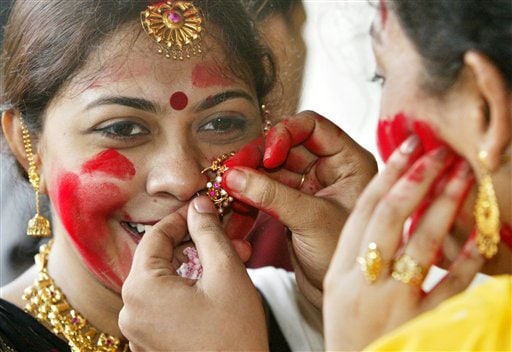 A Hindu woman checks another woman's nose ring as they put vermilion on each other's face as part of a ritual at a Durga Puja venue in Calcutta, India, Monday, October 2, 2006. Hindu festival Durga Puja will end Monday with immersion of idols in the rivers.