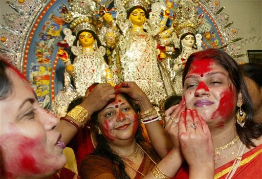 Married Hindu women put vermilion on each other's face as a ritual before an idol of goddess Durga in Calcutta, India, Monday, October 2, 2006. Five-day Hindu festival Durga Puja will end with the immersion of idols at the river Ganges Monday.